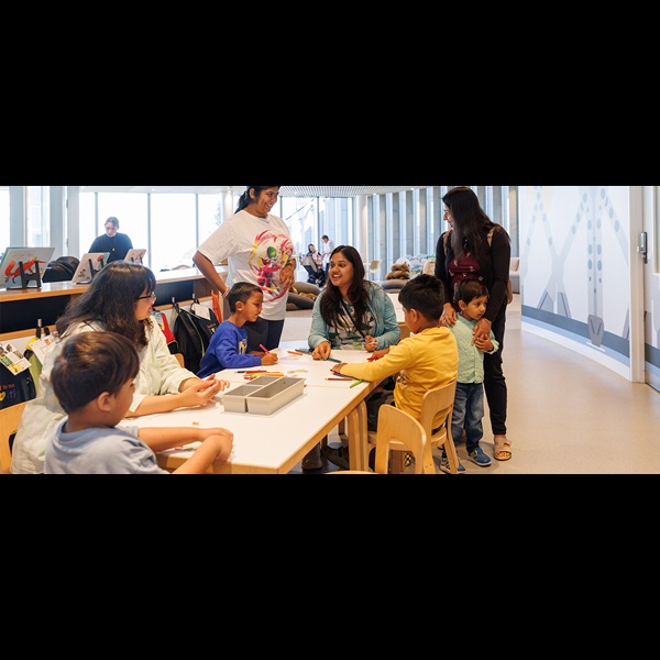 Children and parents colouring in at the tables on Level 4 of the Library.