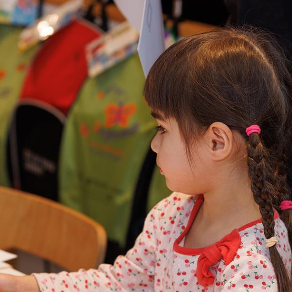 Young girl with plaits participating in a craft activity in the Library.