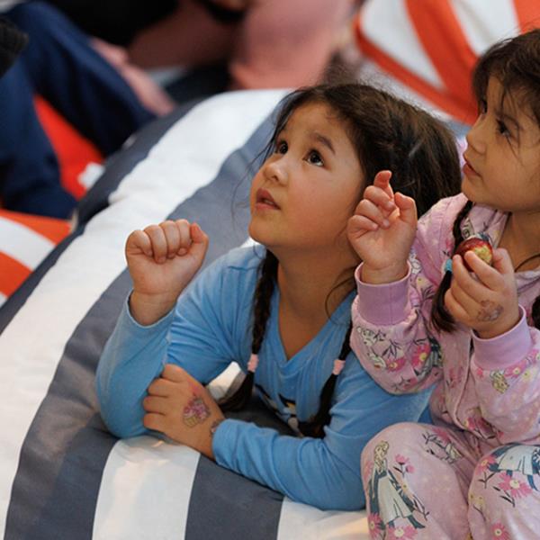 Girls in pyjamas listening to a story.