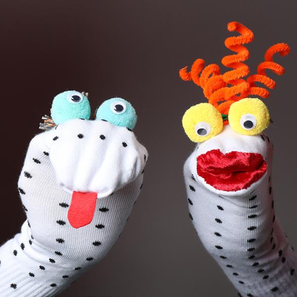 Dotty sock puppets with goggly eyes arranged on a puppet stage.