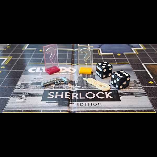 Close up photo of Cluedo - Sherlock edition game board with game pieces and dice.
