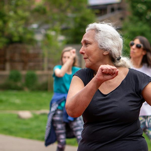 Cheerful, older women exercising outside.