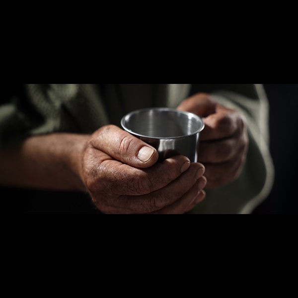 Close up photograph of hands holding a tin cup.