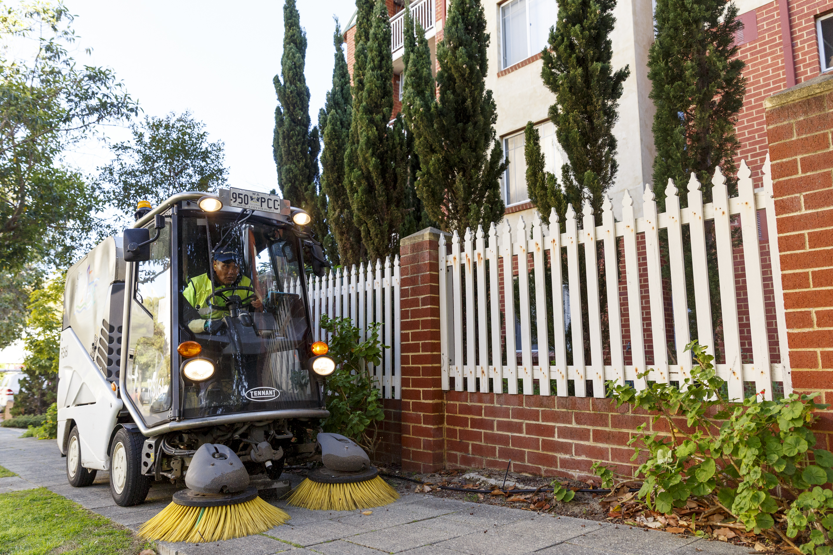 Street sweeper cleaning a city footpath