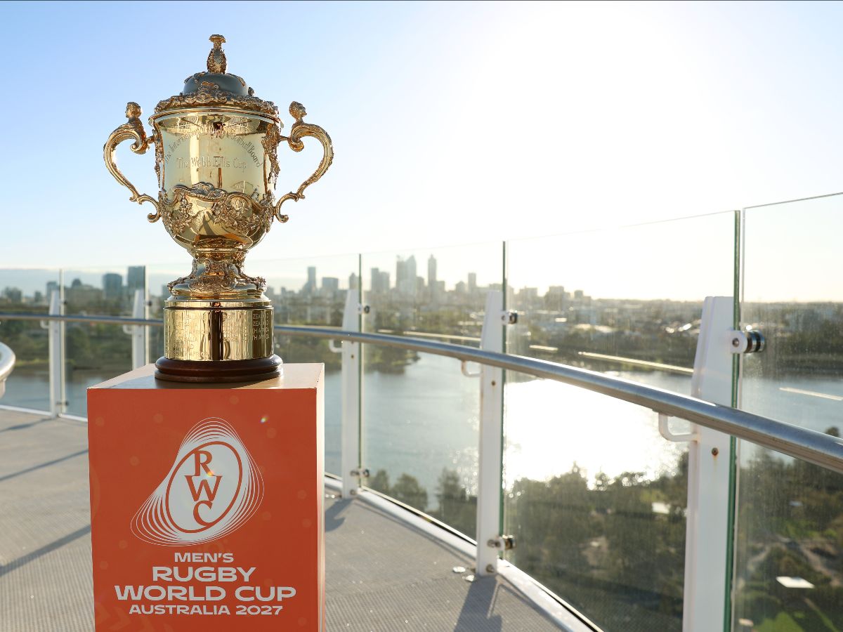Rugby World Cup trophy on an orange plinth with the Perth skyline in the background.