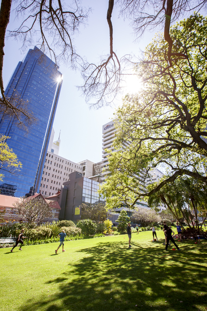 People exercise at Stirling Gardens with city buildings in the background