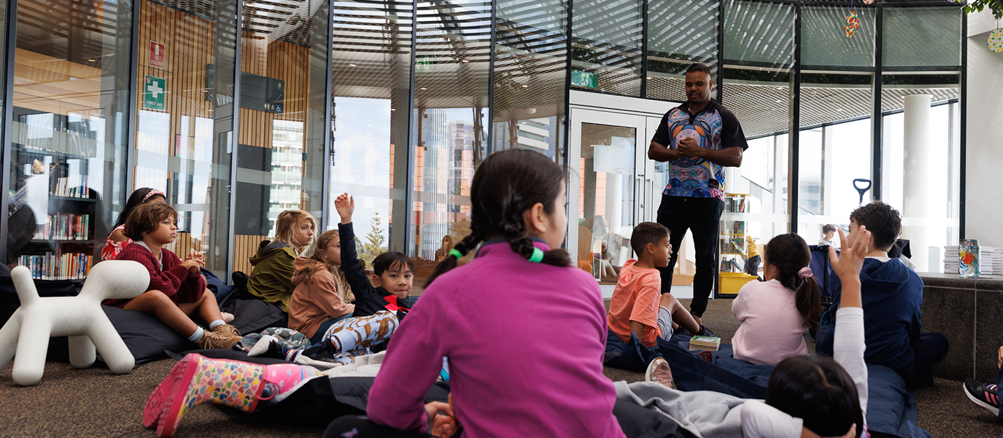 Children in the Tree area of the Library listening to Justin from Djurandi Dreaming
