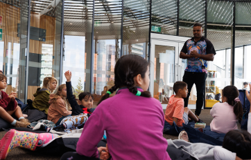 Children in the Tree area of the Library listening to Justin from Djurandi Dreaming