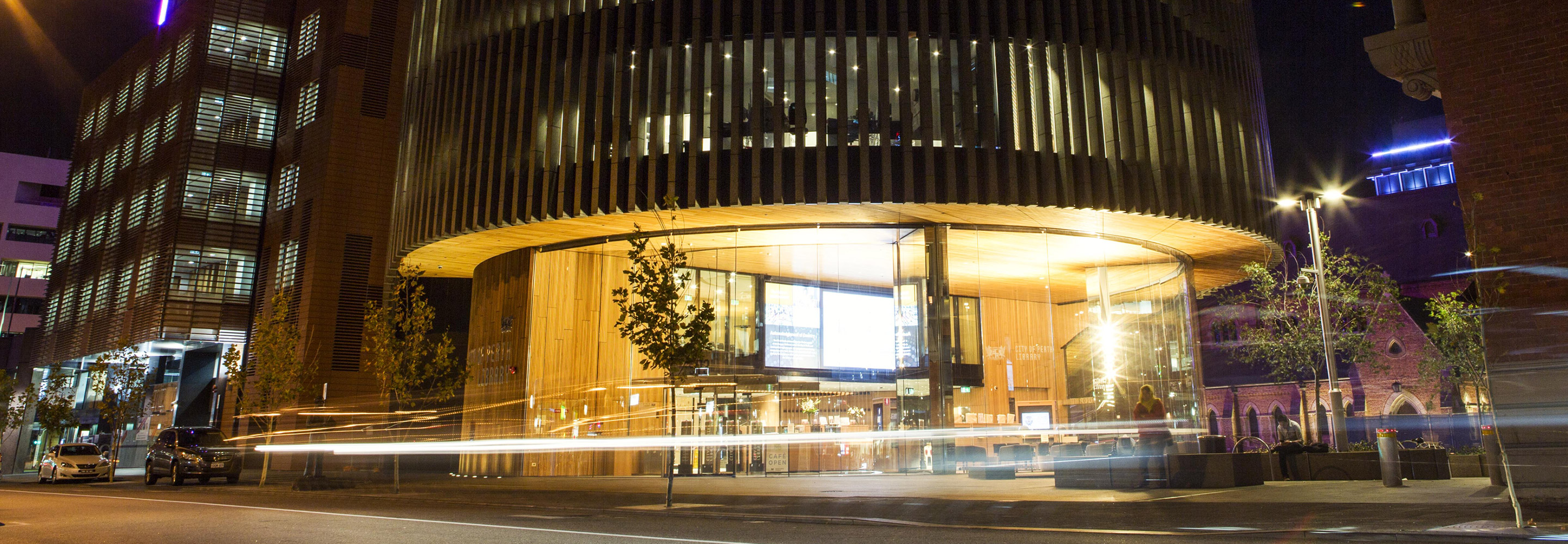 Night shot of Perth City Library with passing cars